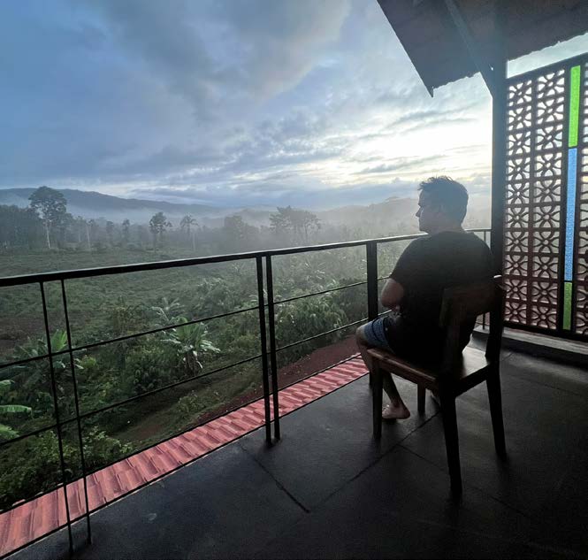 Friends enjoying coffee on balcony with garden view